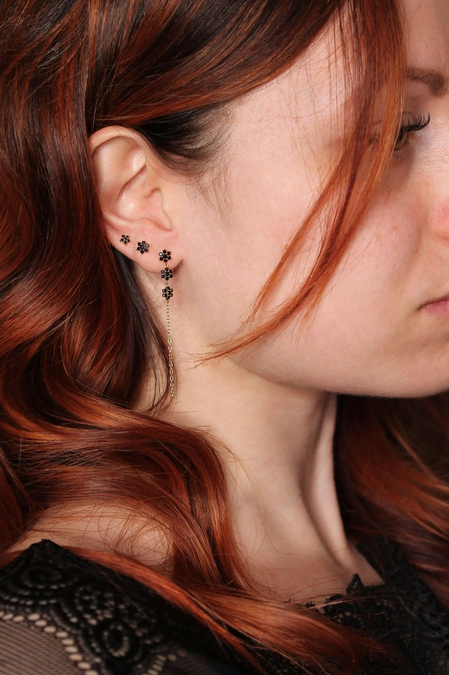 Set de boucles d’oreilles dorées à l’or fin avec pierres noires porté, bijou élégant et raffiné